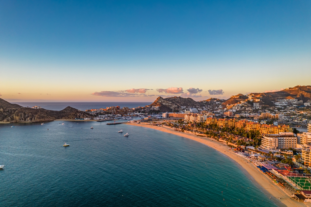 Aerial sunset view of Los Cabos coastline with golden beach and turquoise waters — HauteBlack Mexico culture