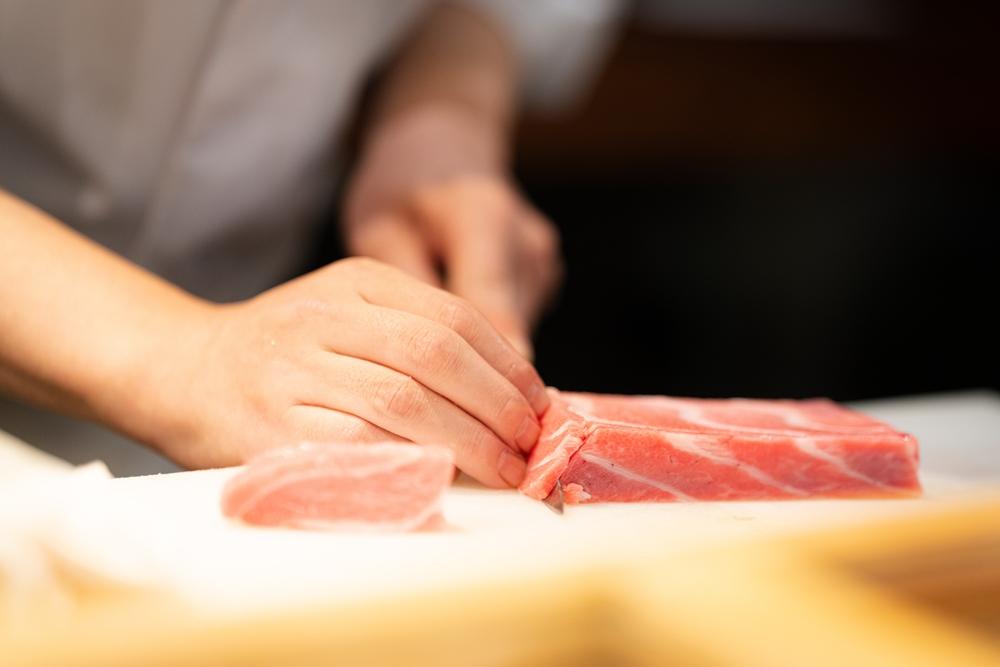 Master sushi chef preparing otoro in Tokyo — omakase counter experience at a Michelin-starred restaurant