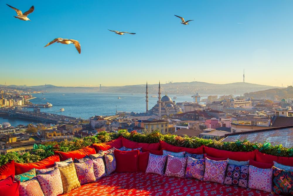 Rooftop terrace with patterned cushions overlooking domes and minarets at golden hour — HauteBlack Morocco Imperial Cities journey